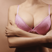 Auf dem Bild ist das Dekolleté einer Frau mit rosa BH zu sehen.