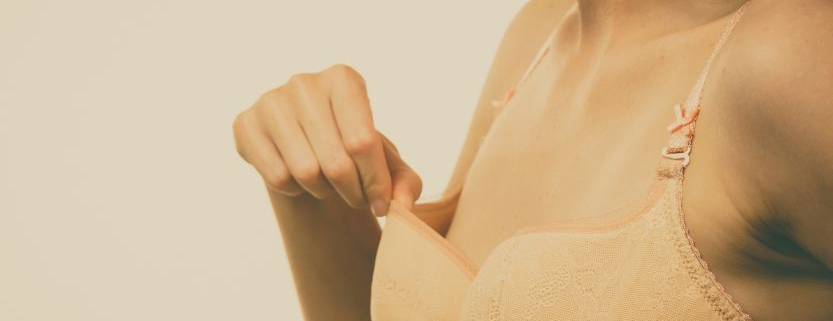 Frau mit der Hand an einem zu großen BH-Körbchen zum Thema Brust OP natürlich mit Eigenfett als Alternative zu Implantaten